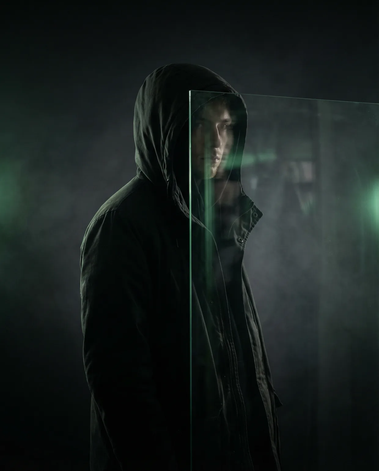 Hooded figure with a streak of lime paint across the face